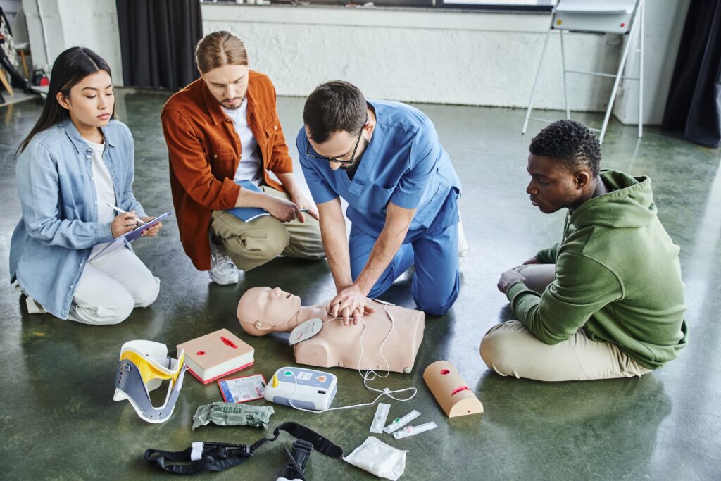 CPR instructor demonstrating chest compressions to students during a hands-on training class